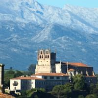 Kirche mit Kloster dahinter hohe Berge