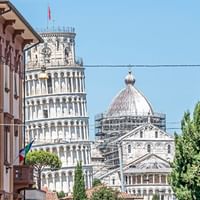 Der schiefe Turm von Pisa hinter der Stadt, und vor der Kirche bei der gerade die Kuppe für die Renovation eingerüstet ist.