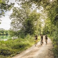 Three cyclists next to a river