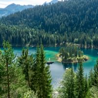 Der Caumasee liegt inmitten dicht bewaldetem Gebiet in der Gemeinde Flims im Kanton Graubünden.