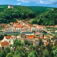 Luftaufnahme von Kelheim, einer bayerischen Stadt mit roten Ziegeldächern in einem Flusstal. Eine Brücke überquert die Donau.
