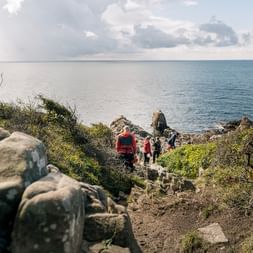 Des randonneurs sur la côte suédoise marchent vers la mer. Vacances de randonnée avec Eurotrek.