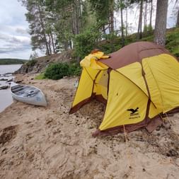 Das aufgestellte gelbe Zelt an einem Sandstrand.