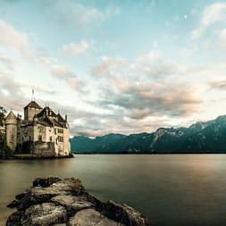 Depuis le lac, on aperçoit le château de Chillon dans l'ambiance du soir.