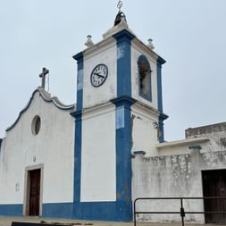 Blaue Kirche mit Uhr in Zambujeira do Mar