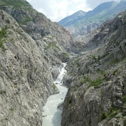Ein kleiner Fluss bahnt sich seinen Weg durch eine Schlucht auf dem Aletsch Panoramaweg.