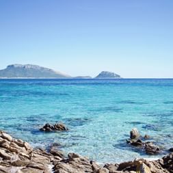 Kristallklares Wasser an der Küste auf Sardinien mit Blick auf das offene Meer.