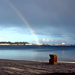 Strandkorb mit Regenbogen im Hintergrund