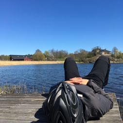 Eine Radfahrerin erholt sich auf dem Steg am See in Schweden.