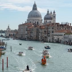 Grosser Kanal in Venedig auf dem wie immer viele Boote unterwegs sind. Im Hintergrund die Kirche von Venedig und ihre grosse Kuppel.