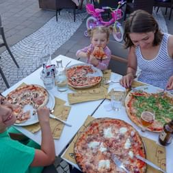 Mami mit ihren zwei Mädels am Pizza essen. Die vierte Pizza wird wohl der Papi nach dem fotografieren essen.