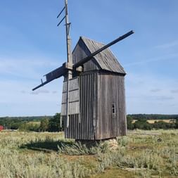 Eine Holzmühle steht auf einem Feld in Gotland.