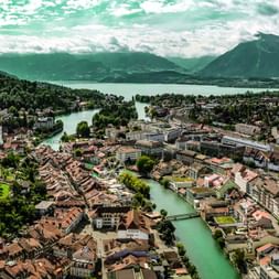 View from above of Thun and Lake Thun with mountains in the background.