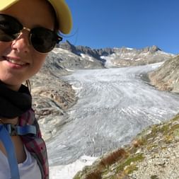 Nina steht vor einem Gletscher auf ihrer Wanderung auf dem 4-Quellenweg.