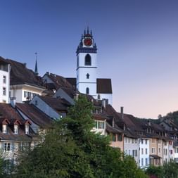 A tall church tower rises above the old town of Aarau.