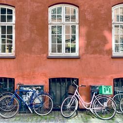 Mehrere Velos stehen vor einer roten Hauswand in Malmö.