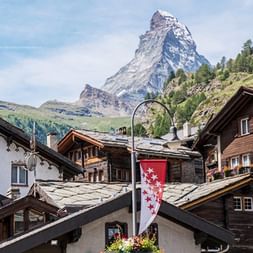 Zermatt village with Matterhorn peak Traditional Swiss chalets in Zermatt with the iconic pyramid-shaped Matterhorn mountain peak rising dramatically in the background.