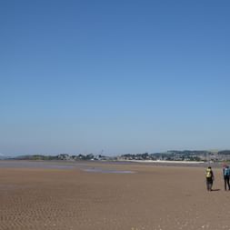 Zwei wanderer laufen bei Ebbe der Küste entlang.