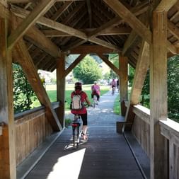 Biker überqueren die Holzbrücke in Langnau.