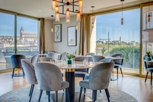 Modernes Restaurant mit Samtstühlen, runden Tischen und bodentiefen Fenstern mit Blick auf die Kathedrale von Blois und die Loire.