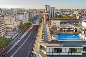 Luftaufnahme des Dachpools und der Terrasse des Hotel Jupiter Lisboa mit Blick auf Lissabons Stadtbild mit modernen Gebäuden.
