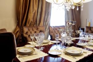 Elegantes Restaurant im Hotel Moliceiro Aveiro mit dunklem Holztisch, Kristallleuchter, gepolsterten Stühlen und formeller Tischdekoration.