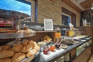 Frühstücksbuffet im Hotel Ertl mit frischen Brötchen, Saftautomaten, Marmeladen, Müsli und verschiedenen Frühstücksartikeln.