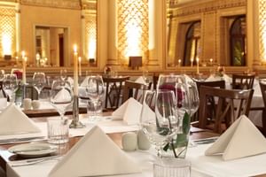 Elegantes Restaurant-Interieur der Alte Post Konstanz mit weißen Tischdecken, Weingläsern und verzierten Säulen bei warmem Licht.