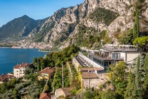 Villa Dirce Hotel in Limone mit moderner Terrassenarchitektur am Hang über dem Gardasee, umgeben von dramatischen Kalksteinfelsen.