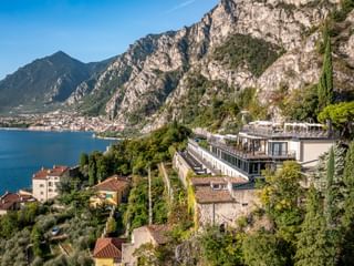 Villa Dirce Hotel in Limone mit moderner Terrassenarchitektur am Hang über dem Gardasee, umgeben von dramatischen Kalksteinfelsen.