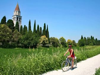 Radler vor der Basilika von Aquileia