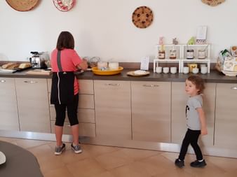 Frau und ein Kind beim Frühstücksbuffet im Ferienhaus