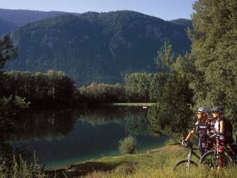 Two mountain bikers take a break on the lakeshore.