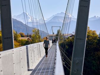 Personen, die die Betonbrücke auf dem Panoramaweg am Thunersee überqueren