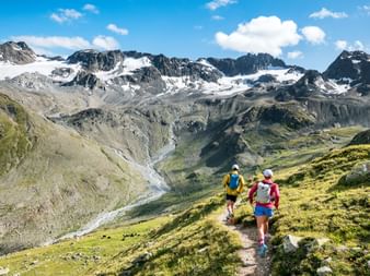 Two trail runners are on the Eurotrek trail running tour on the Via Grischuna in the canton of Graubünden.
