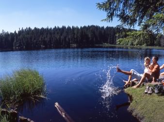 Plusieurs personnes font une pause au bord d'un lac dans le Jura.