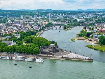 Vue aérienne de Coblence montrant la confluence de deux rivières avec le monument Deutsches Eck, bâtiments historiques et ponts.