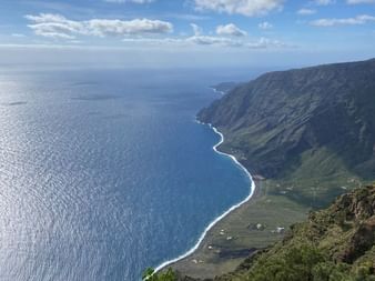 El Hierro Küstenaussicht zur Mittagszeit Panoramablick auf El Hierros Küste von erhöhtem Aussichtspunkt mit dramatischen Klippen, geschwungener Küstenlinie und tiefblauem Atlantik.