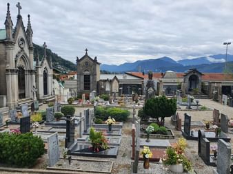 Ein Friedhof mit vielen Gräbern und eine traditionelle Trauerhalle in der Nähe von Lugano.