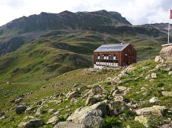 Le refuge Kesch trône sur le front d'une élévation dans les montagnes.