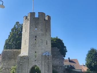Eine Velofahrerin fährt durch den Turm einer Mittelalter Burg in Gotland.