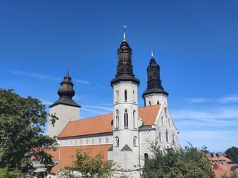 Eine weisse Kirche mit schwarzen Türmen steht im Zentrum von Visby auf Gotland.