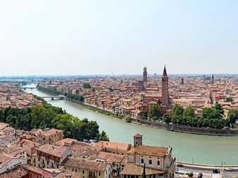 Luftpanorama von Veronas historischer Altstadt mit roten Ziegeldächern, der Etsch, die sich durch die Stadt schlängelt, und Kirchtürmen.