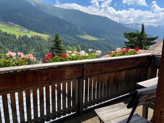 Eine Terrasse mit Blumenschmuck und Talblick