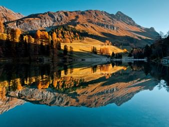 Herbstliche Spiegelung des Bergpanoramas im See.