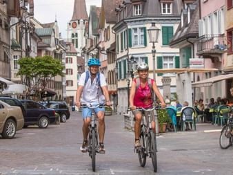 Un couple circule à vélo dans la vieille ville d'Altstätten, dans le canton de Saint-Gall.