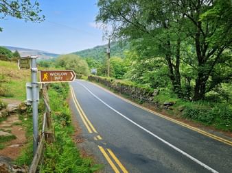 Wanderschilder des Wicklow Way nach Laragh neben einer Straße