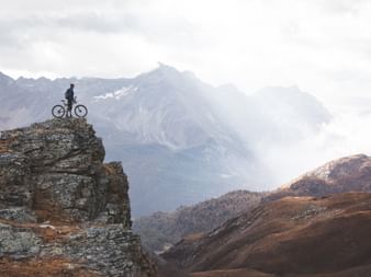 Ein Biker geniesst die Aussicht oberhalb von Pontresina auf der Alpina Bike Tour.