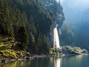 Tosender Wasserfall am Ufer des Oeschinensees. Via Alpina. Wanderferien mit Eurotrek.