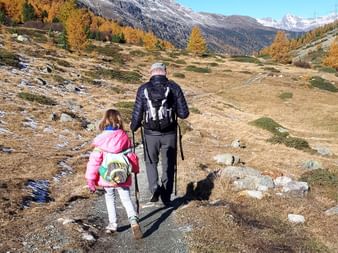 Ein Wanderer wandert mit Kind durch die Berge auf der Bernina Tour.